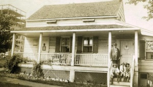 Photograph of Arthur Conan Doyle with his children, Denis, Adrian and Billie standing outside Edgar Allan Poe''s house at Fordham, New York in America